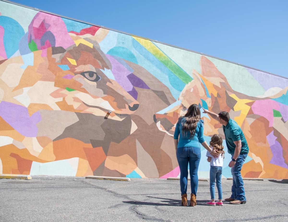 Family of three looking at fox mural in downtown Amarillo, Texas