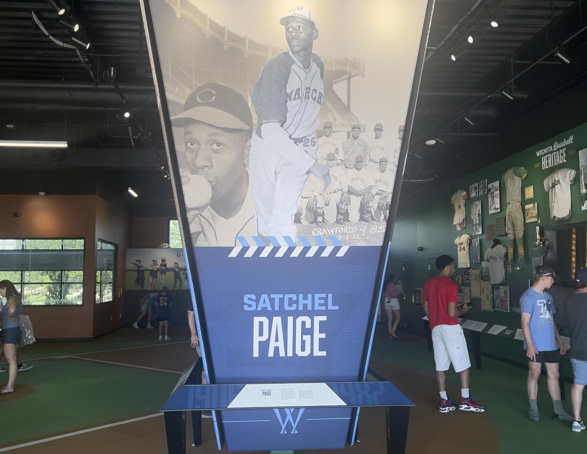The Satchel Paige exhibit at the Wichita Baseball Museum sits on display while visitors look at memorabilia