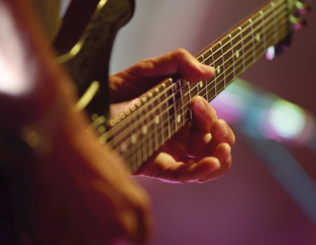 Close up of musician playing guitar at a Ray Brothers Barbeque concert