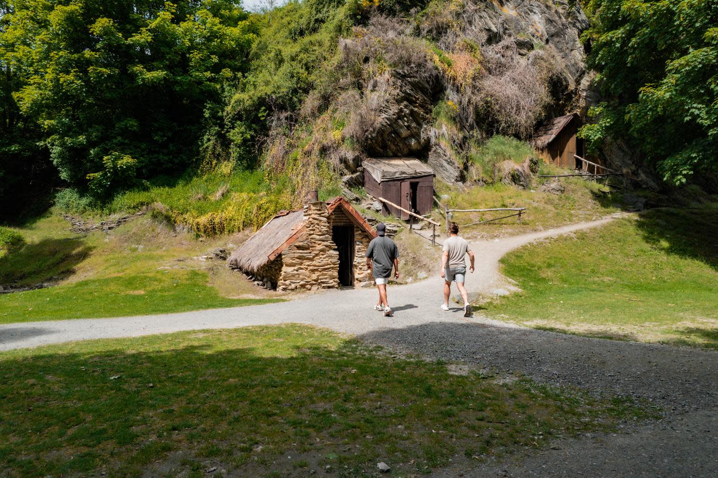 People exploring the historic Chinese Village huts in Arrowtown