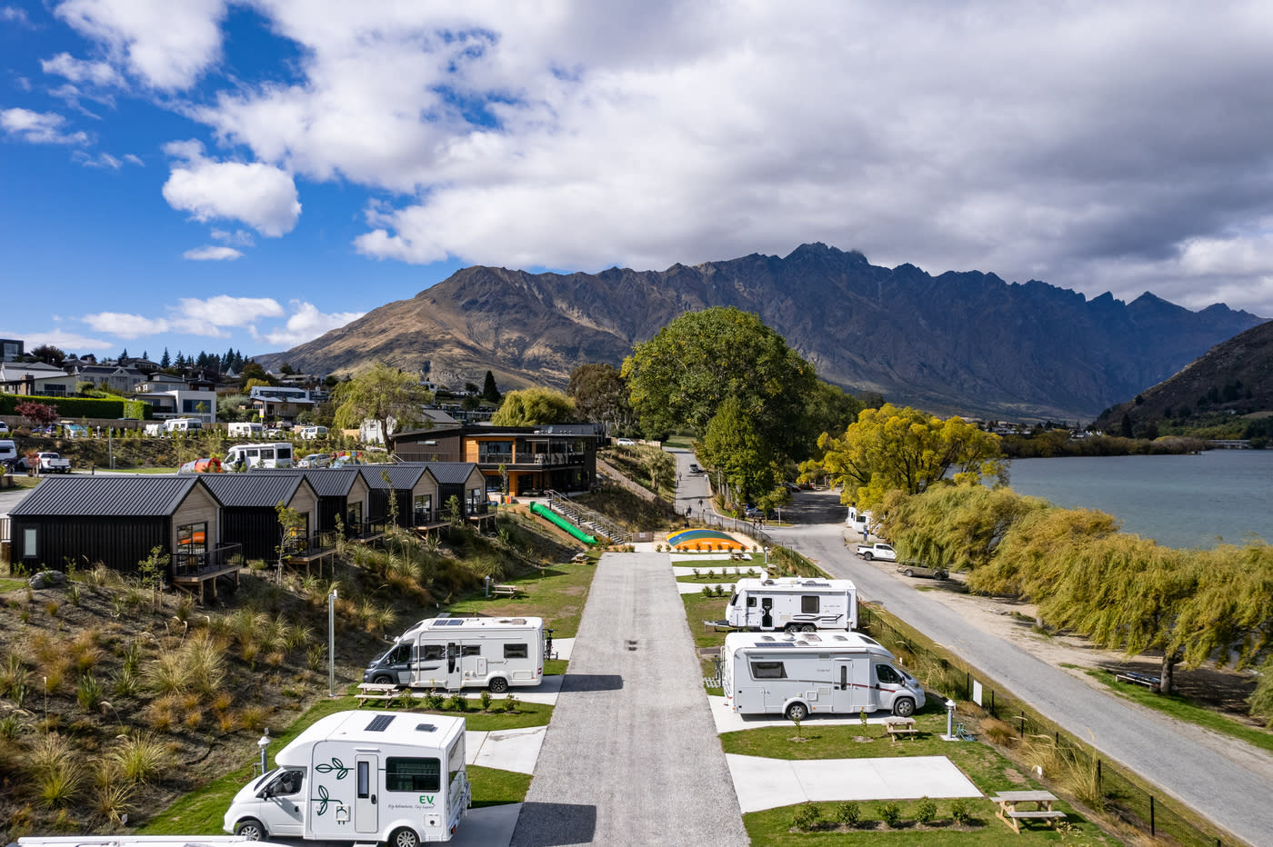 Campervans parked lakeside at Driftaway Holiday Park in Queenstown