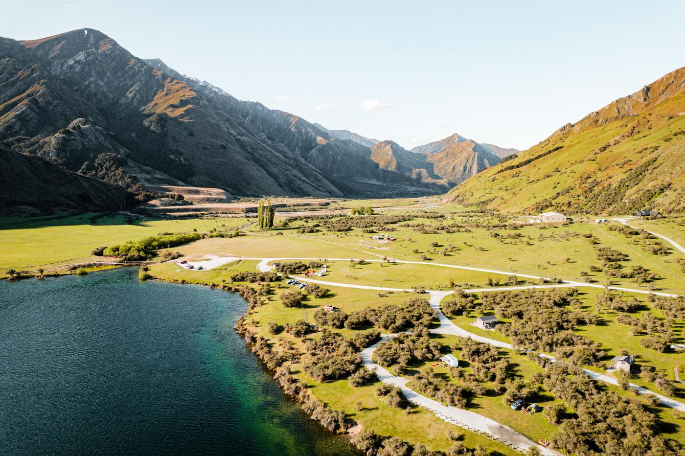 Birdeye view of lake with green landscape and mountains in the background