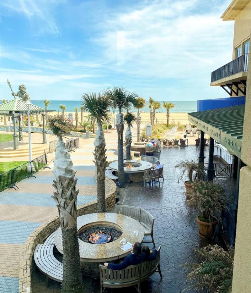 firepit tables outside of a restaurant on the boardwalk