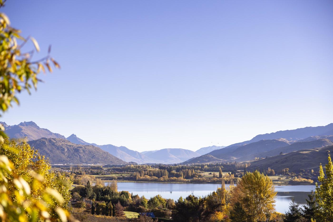 Aerial view of a glassy lake and mountains in autumn