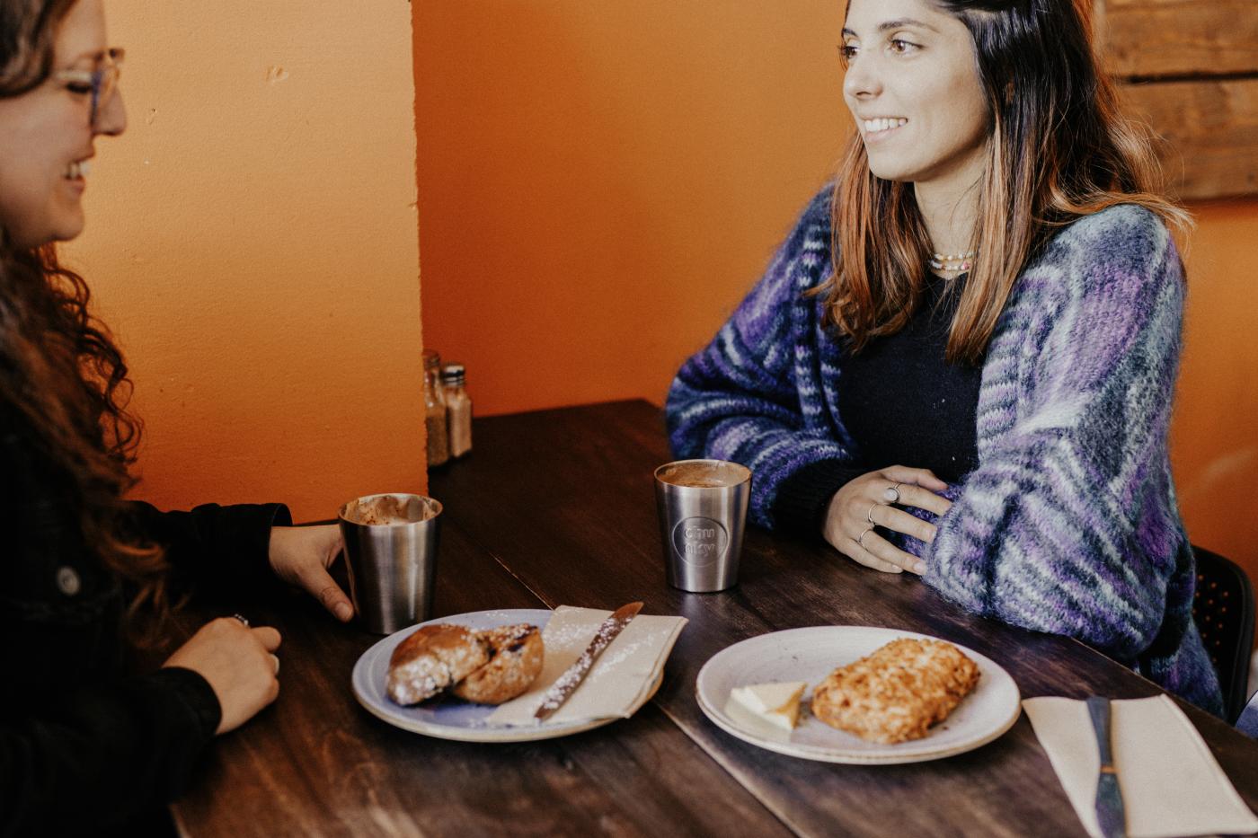 Two people enjoying coffee and scones at Hustl. Café.