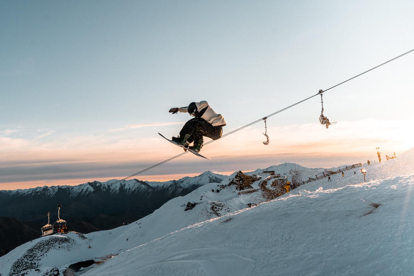 Snowboarder doing a trick at Coronet Peak at Sunset