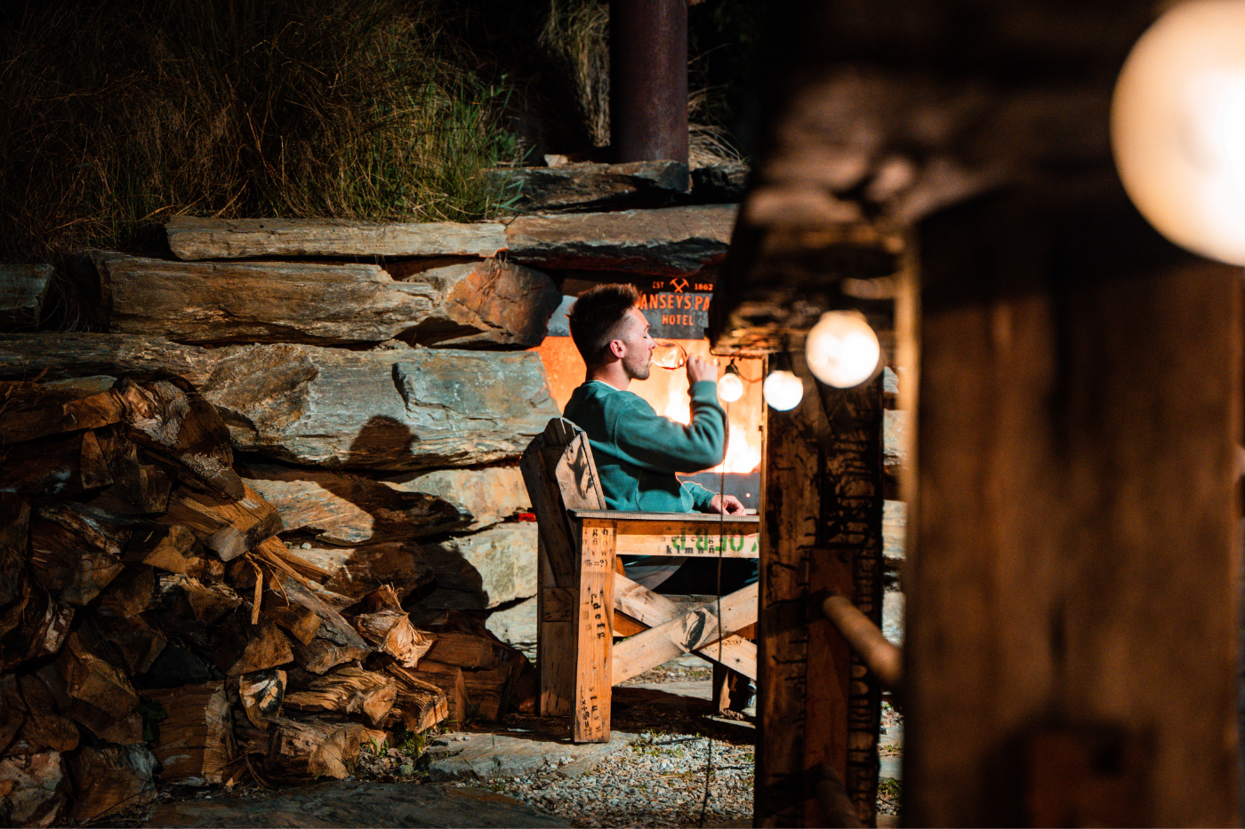 Man drinking beer by the fire at Danseys Pass Hotel, Naseby