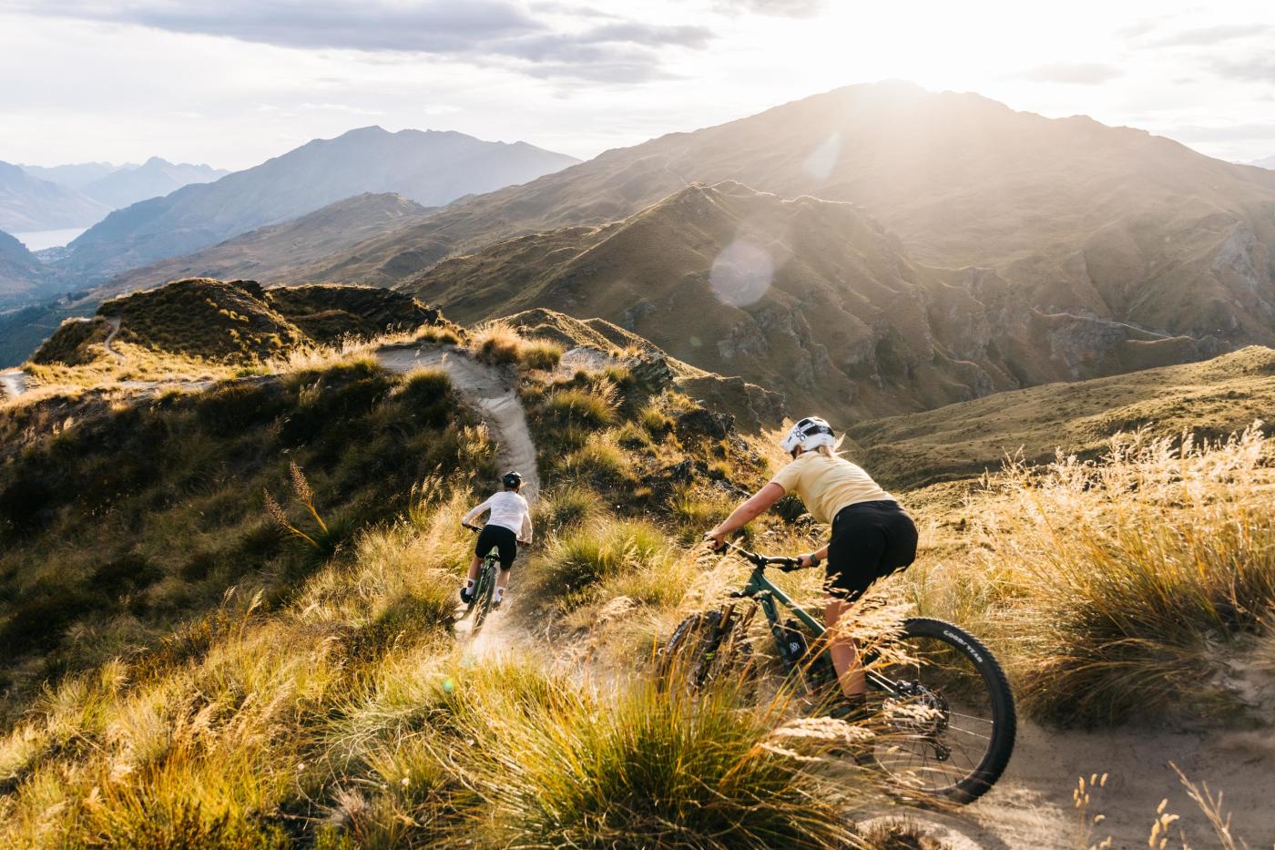 Two people riding mountain bikes through the mountains