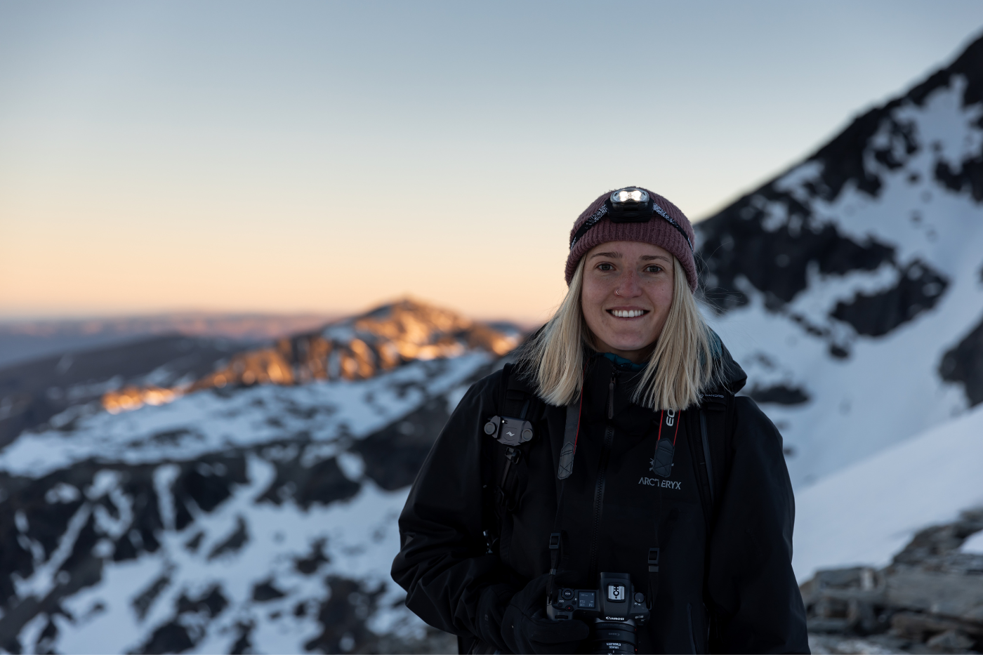 Head shot of photographer Krista May with camera on a mountain