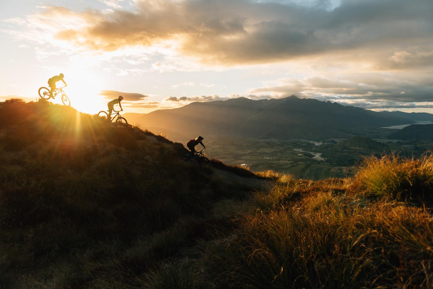 Mountain bikers at sunset biking Rude Rock, Coronet Peak Mountain Bike Trail