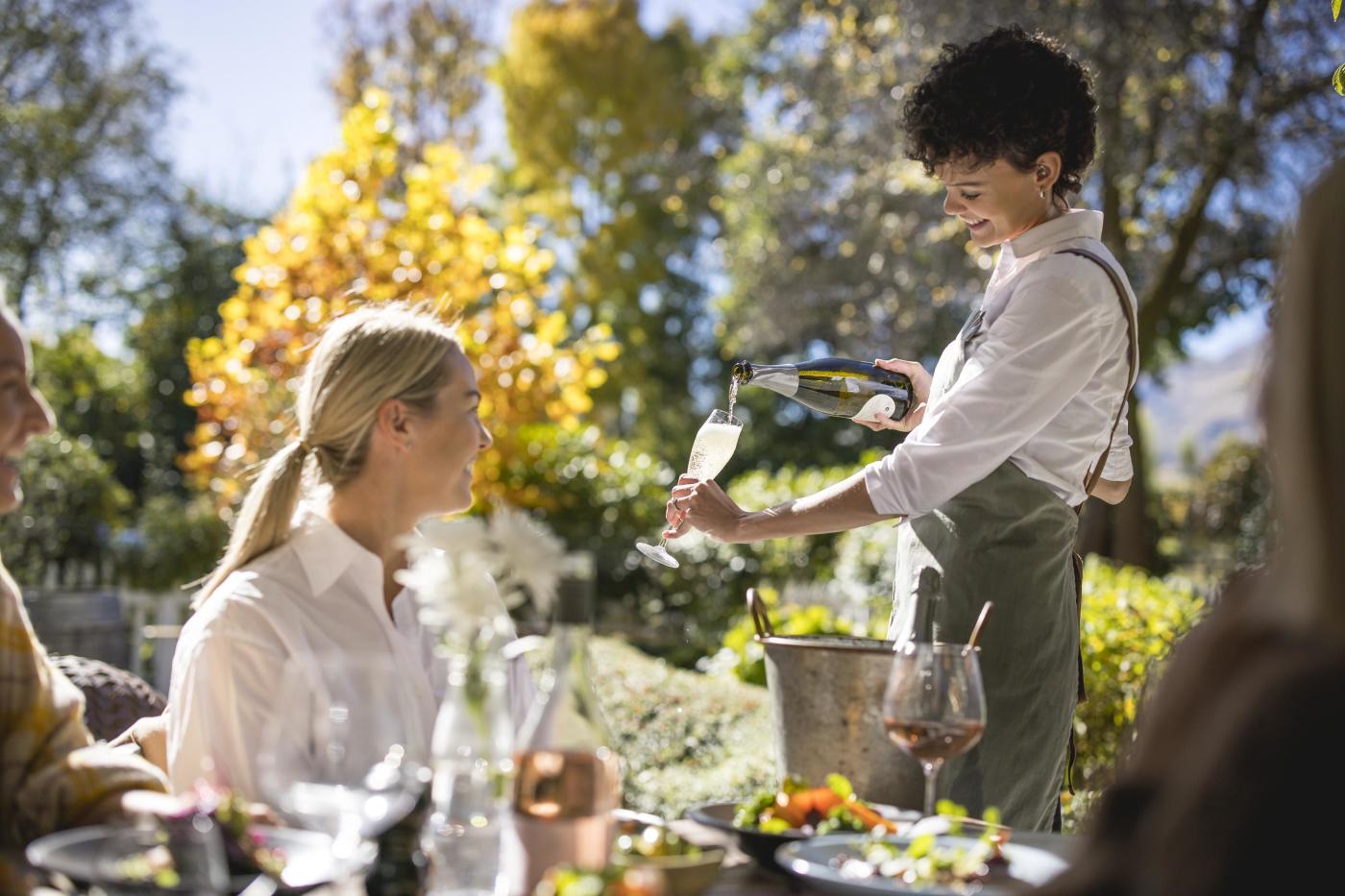 Waitress pouring champaign for guest