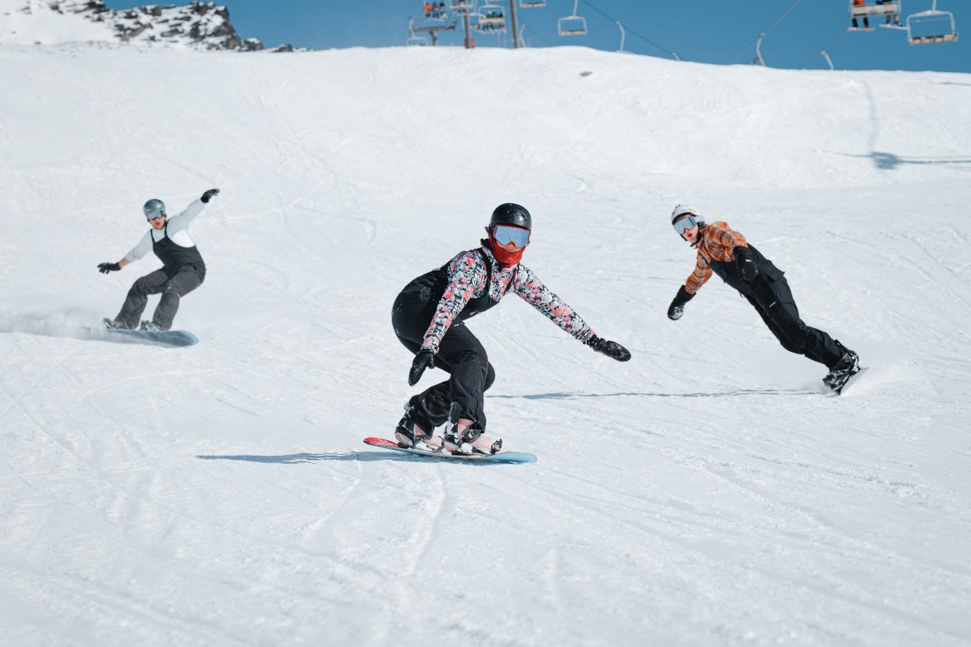 Group of snowboarders shredding Coronet Peak in spring