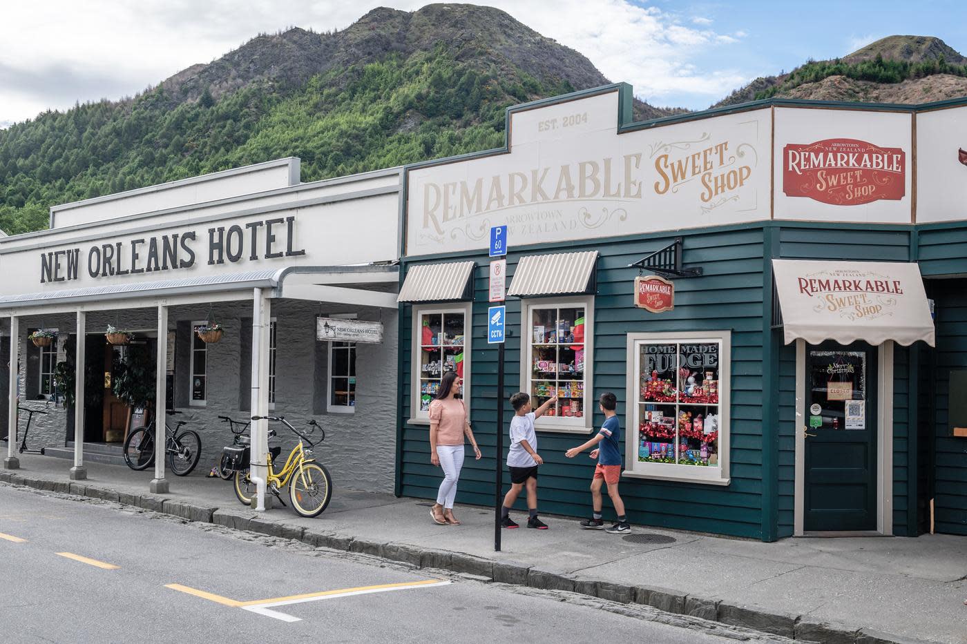 Mother and children walking past the Remarkable Sweet Shop store in Arrowtown