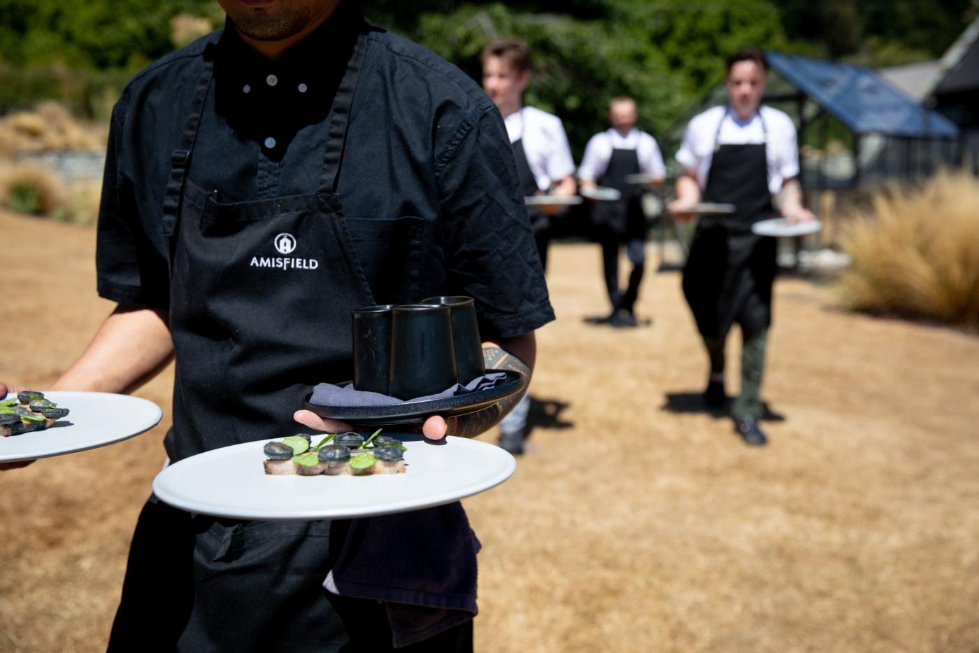Waiter carrying out plates of food