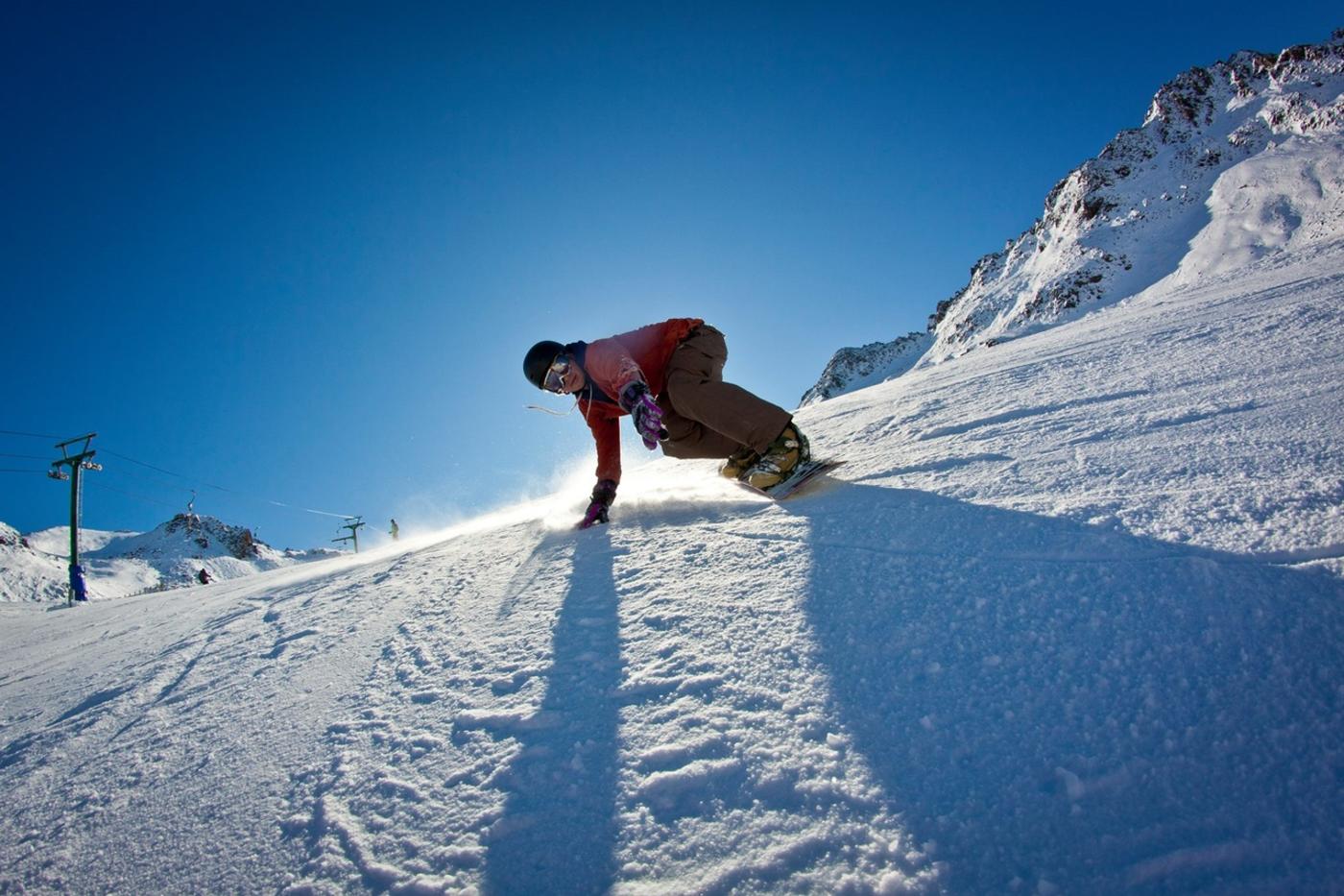 Snowboarder riding down a slope at Rainbow Ski Area