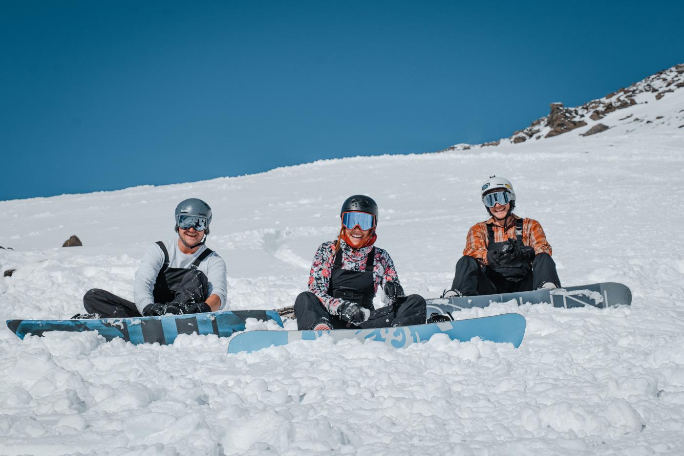 Three Snowboarders at sitting on the slope at The Remarkables