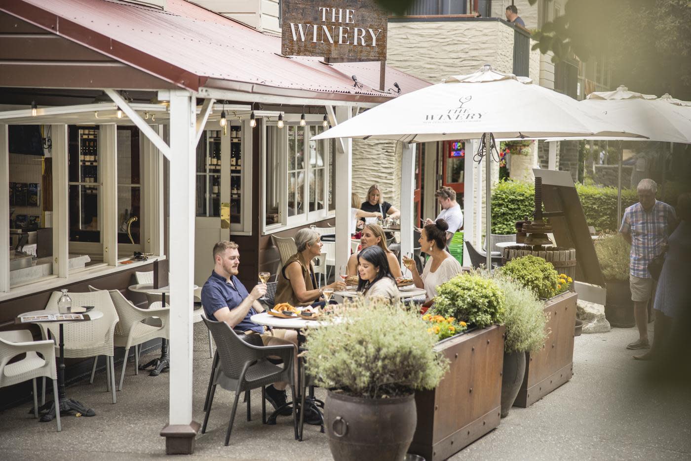 People seated in the outdoor courtyard area at The Winery, Arrowtown