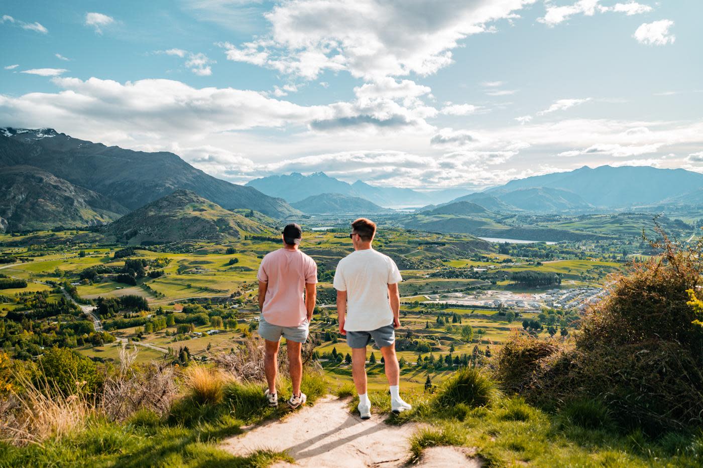 People people standing at the top of Tobin's Track looking out over a green valley and mountain