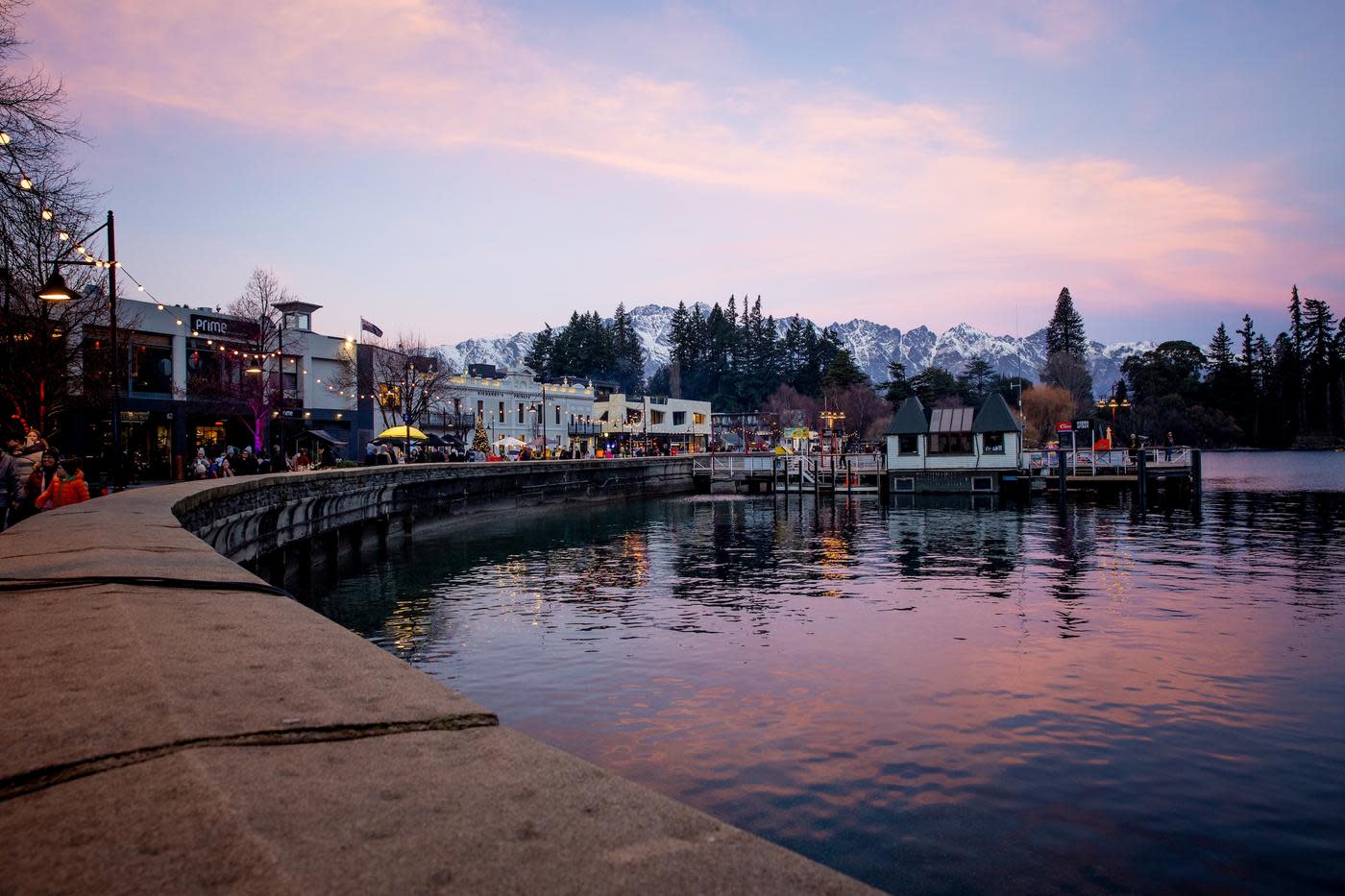 Queenstown waterfront in winter at sunset with the Remarkables mountain range covered in snow