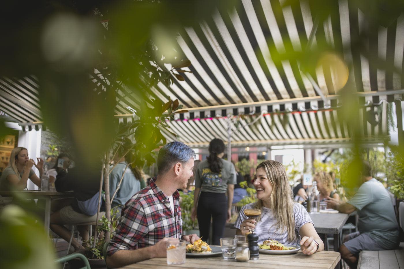 A couple sat at a table enjoying cocktails and brunch at Yonder cafe in Queenstown