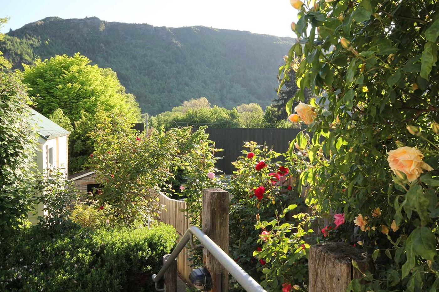 Lush garden with mountain in the background at Arrowtown Lodge