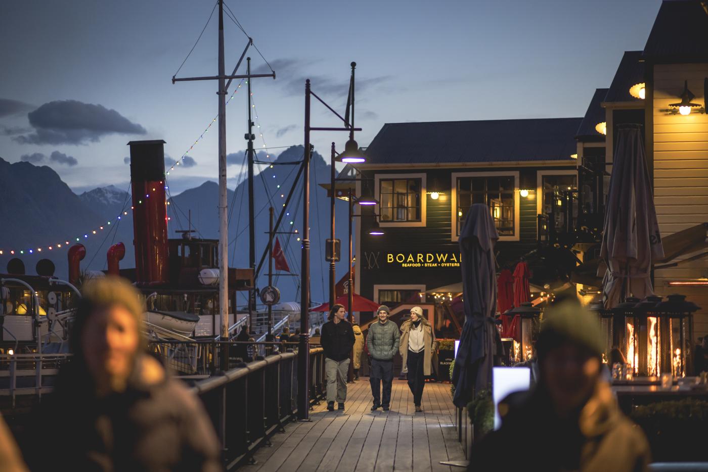 Friends walking through Steamer Wharf on a winter evening