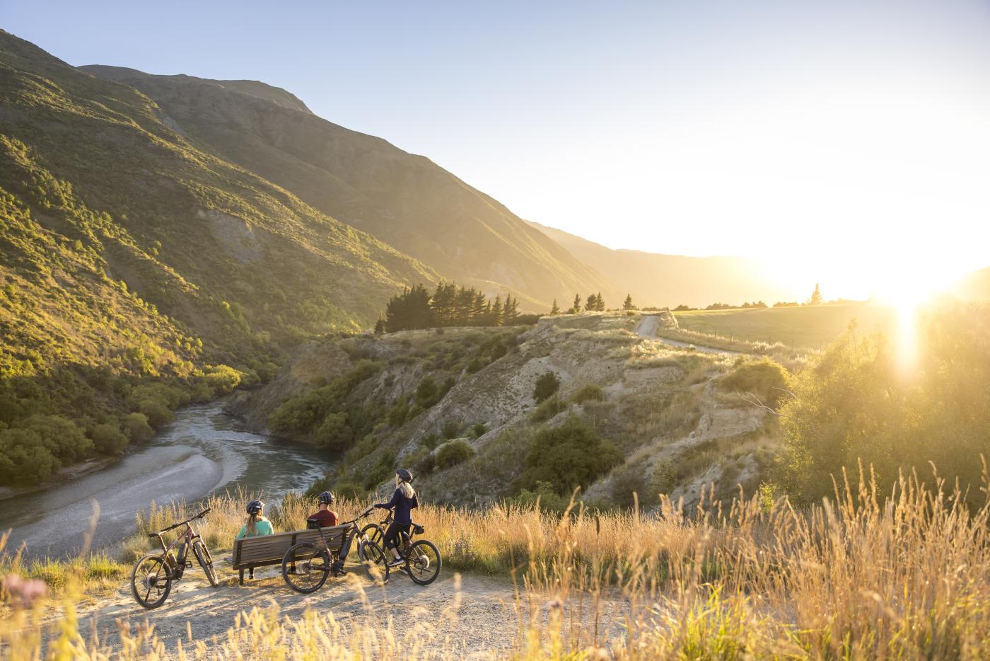 A group of cyclists taking a break next to Gibbston River