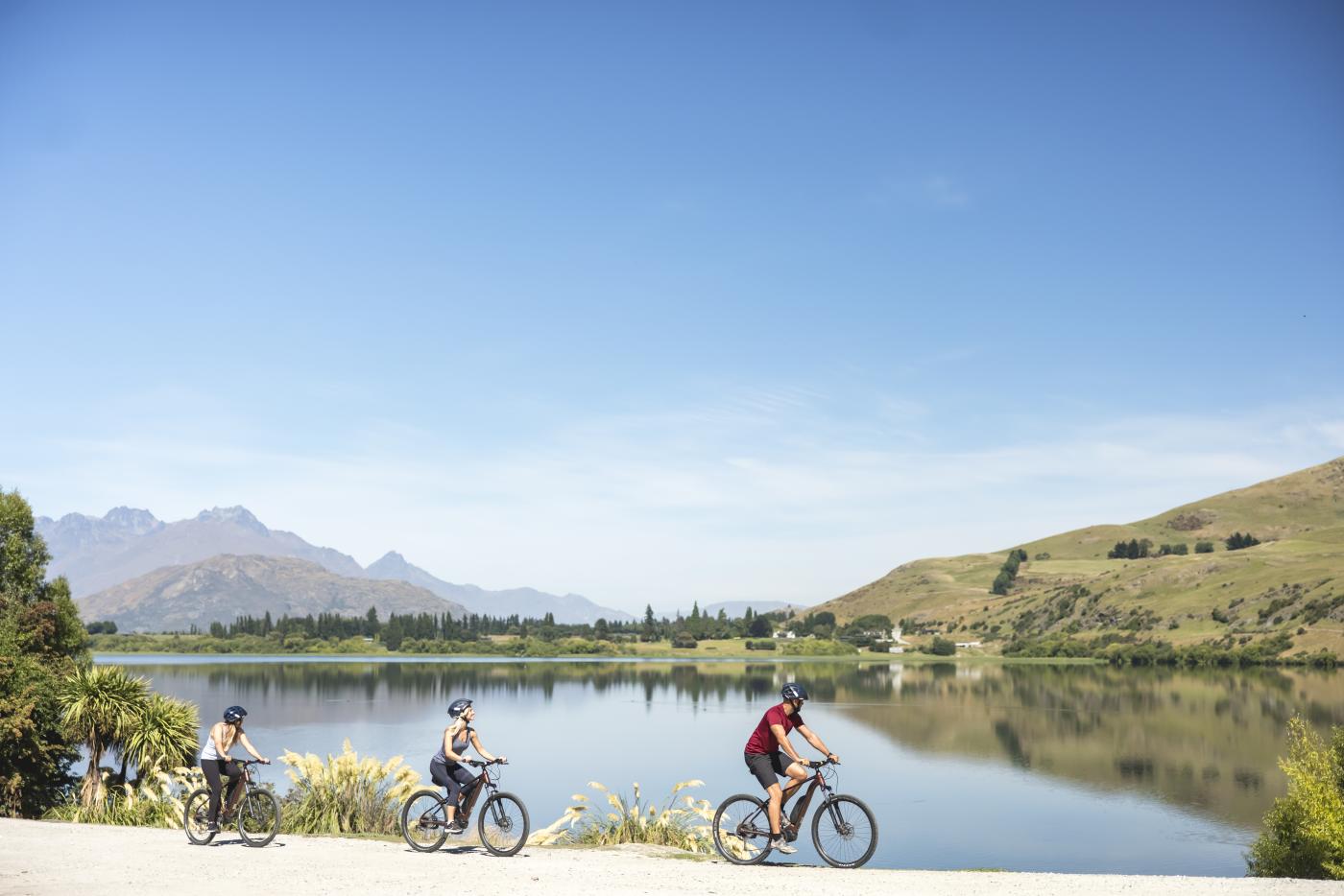 Friends biking Lake Hayes loop track in Summer