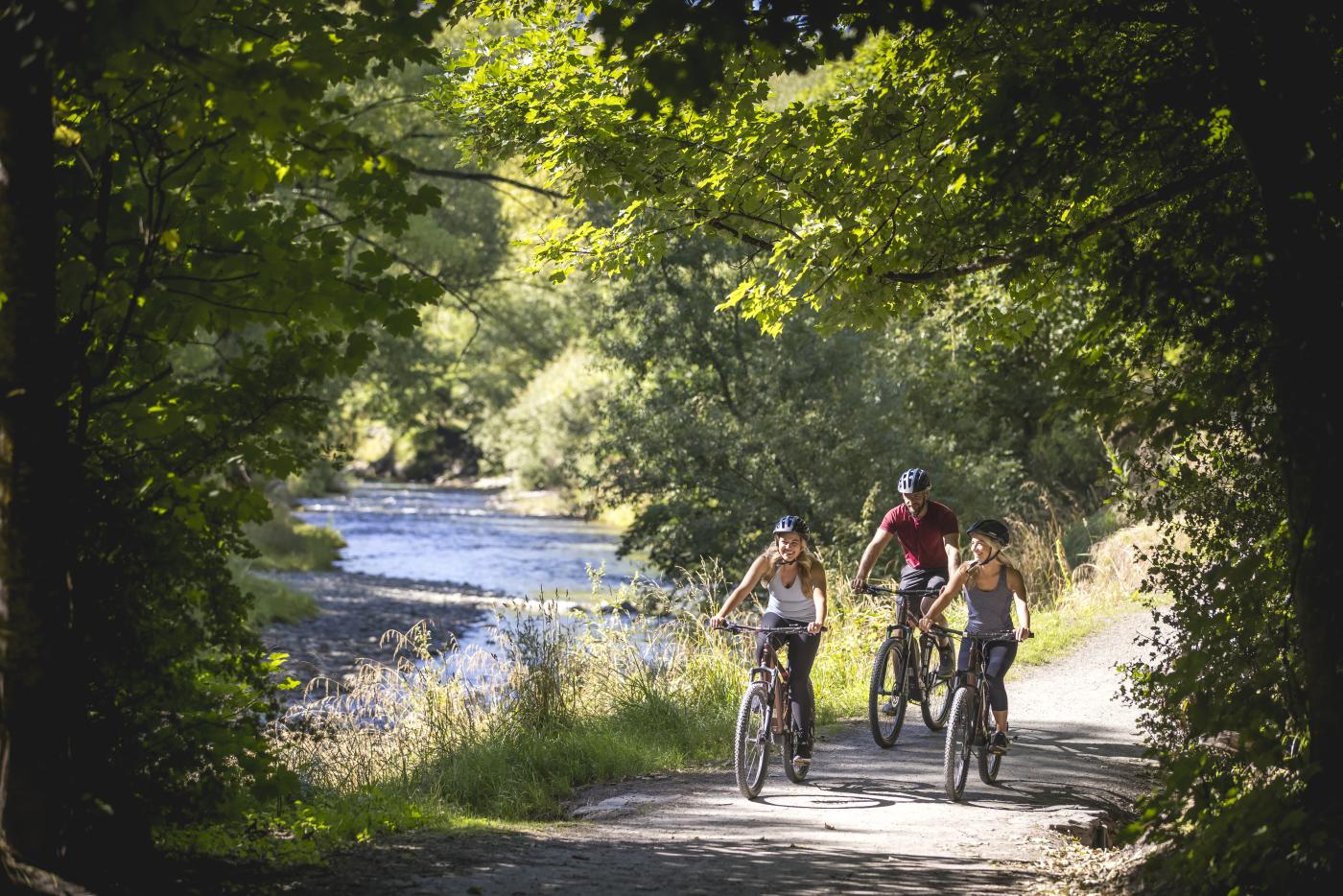 Friends biking alongside the Arrow River, Arrowtown