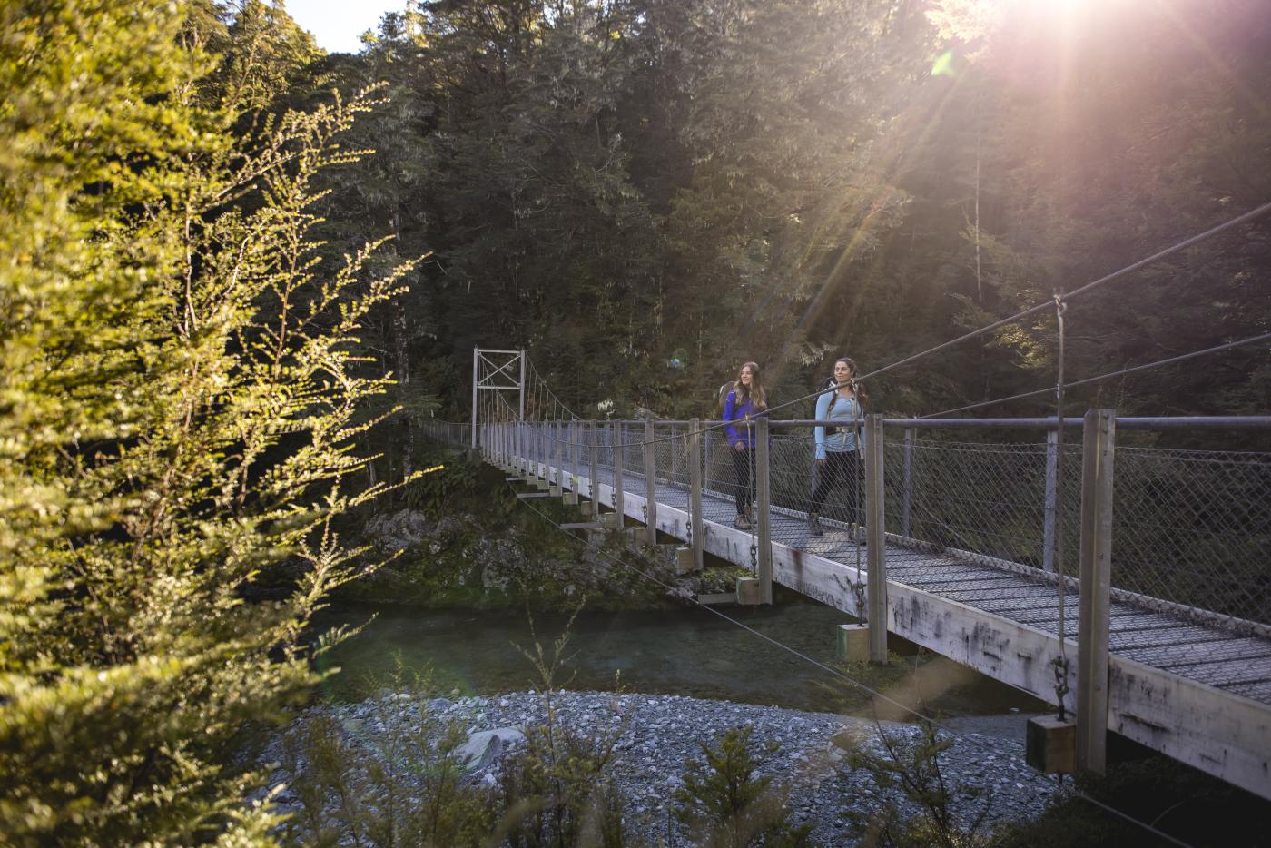 Two female hikers on the Routeburn Track swing bridge
