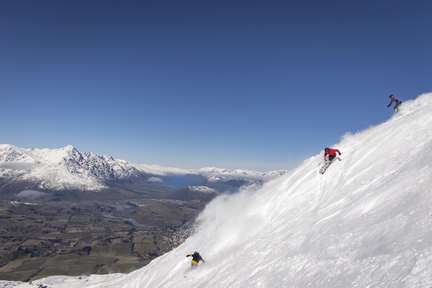 Friends skiing Coronet Peak on a bluebird day