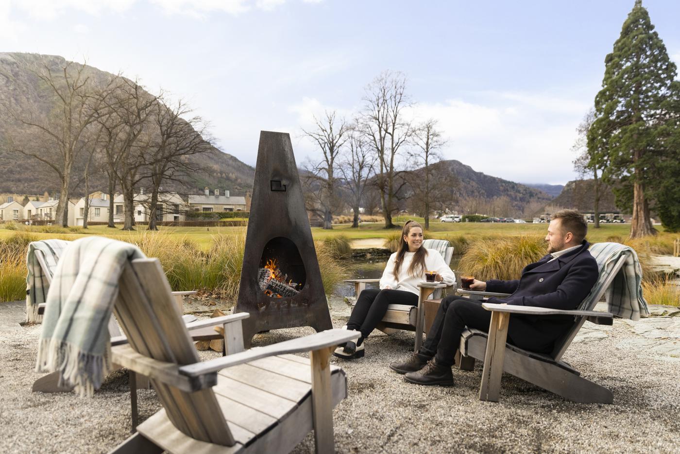 People enjoying at mulled wine by an outdoor fire at Smithy's Smoke House, Millbrook Resort