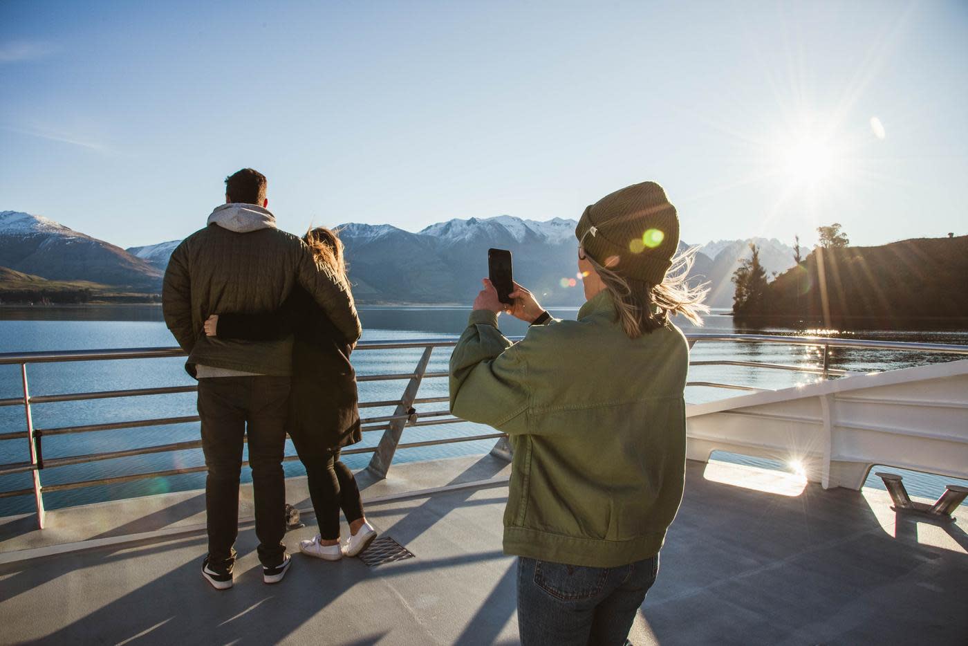 Person taking a photo of a couple on the Spirit of Queenstown Lake Cruise, Southern Discoveries