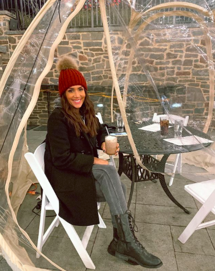 A smiling patron sitting in a plastic Igloos at Yankee Doodle Tap Room in Princeton