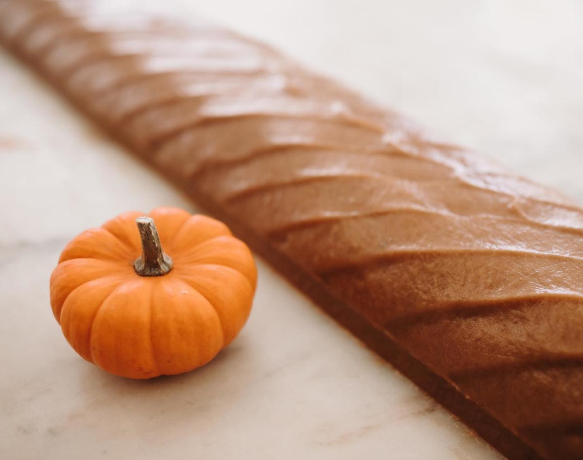A loaf of Mackinac Island fudge on a marble slab next to a tiny orange pumpkin