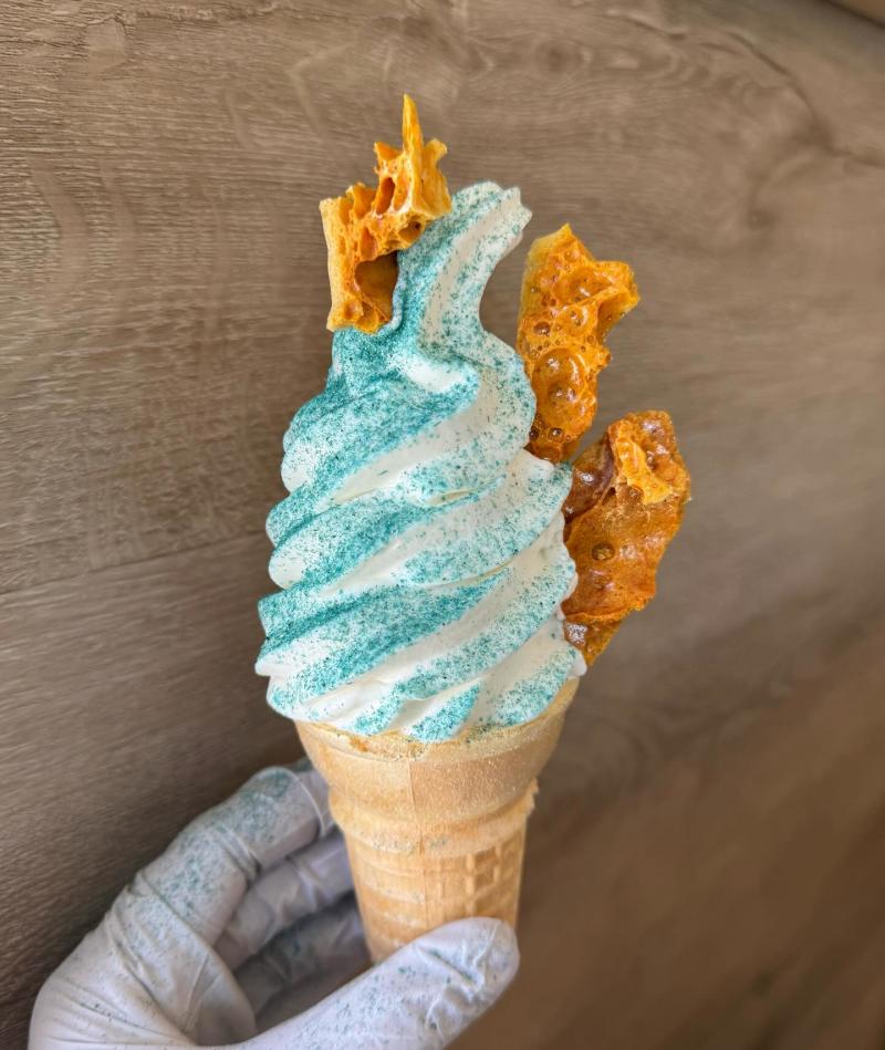 An ice cream cone with vanilla ice cream, blue sugar and honeycomb from Pink Pony Soft Serve