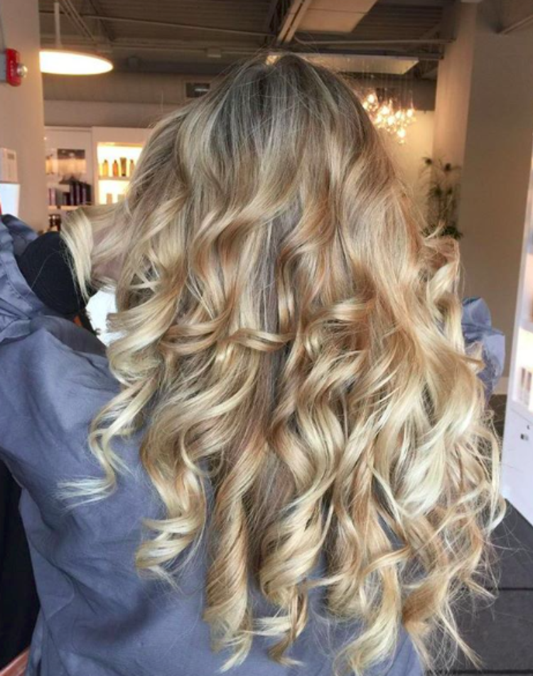 A woman with her back to the camera shows off blonde curls
