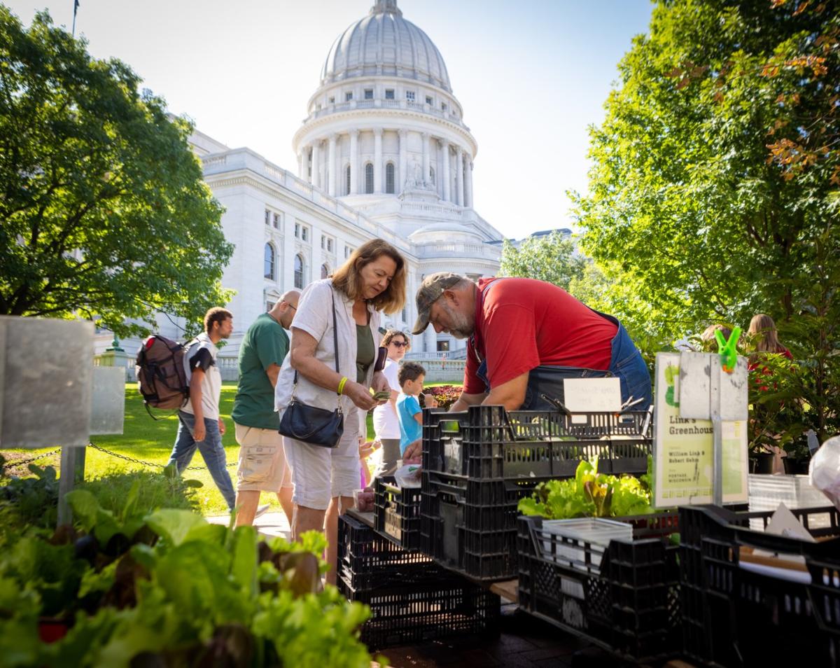 A woman buys produce at the Dane County Farmers' Market