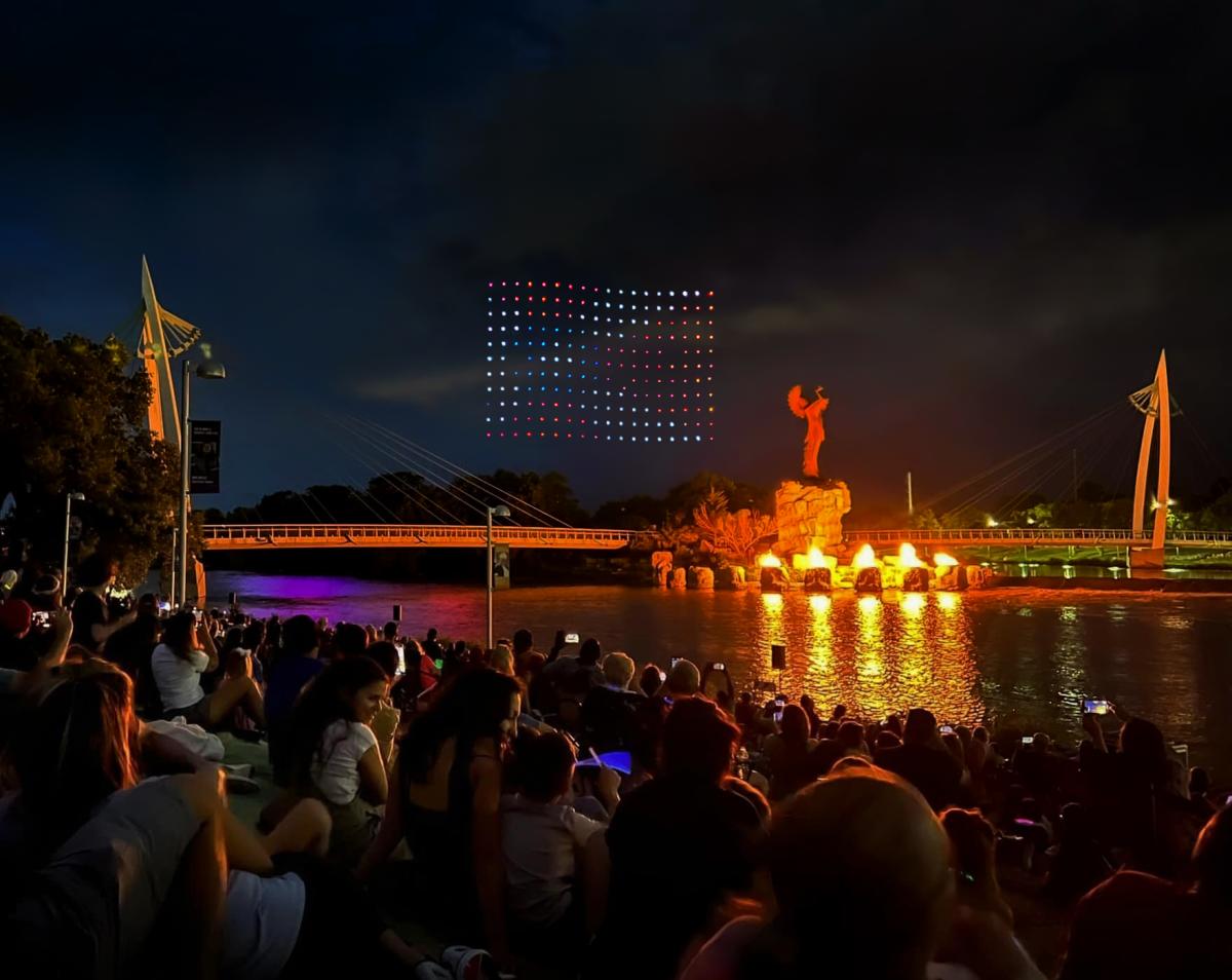 Drone lights create a Wichita Flag in the sky over the Keeper of the Plains in downtown Wichita