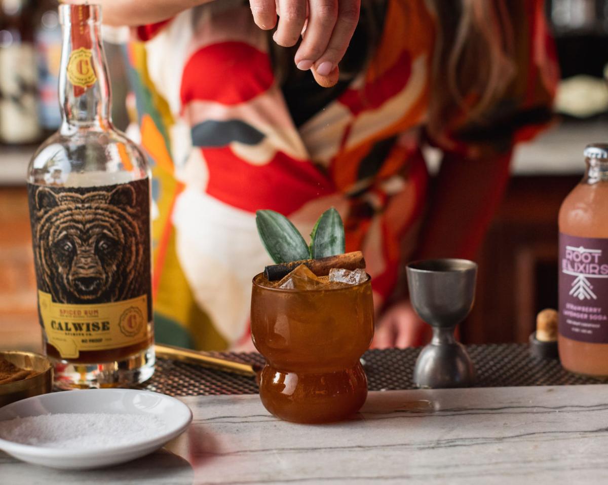 woman making cocktail with Root Elixers cocktail mixer