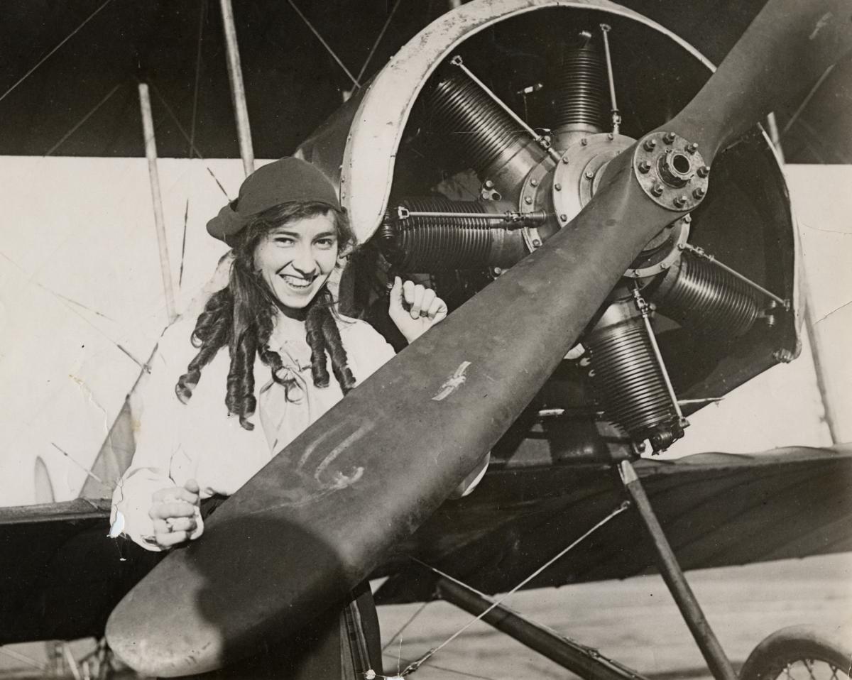 Pilot Katherine Stinson posing behind a propeller head, ca. 1910–19