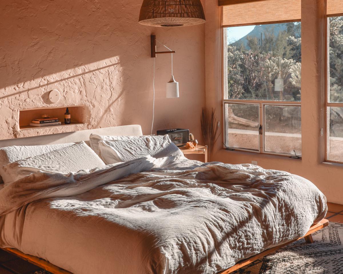 Cozy Neutral bedroom with Sun filtering in from large windows