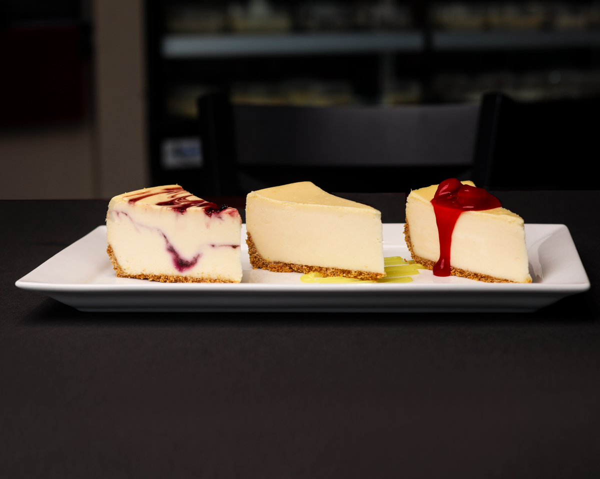 Three pieces of cheesecake are topped with different sauces at Wichita Cheesecake Company