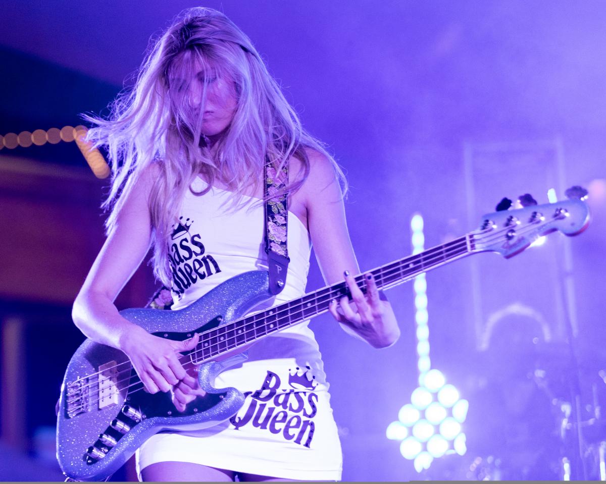 A woman with long blonde hair plays a guitar during a concert at the 2024 Elsewhere Fest at WAVE.