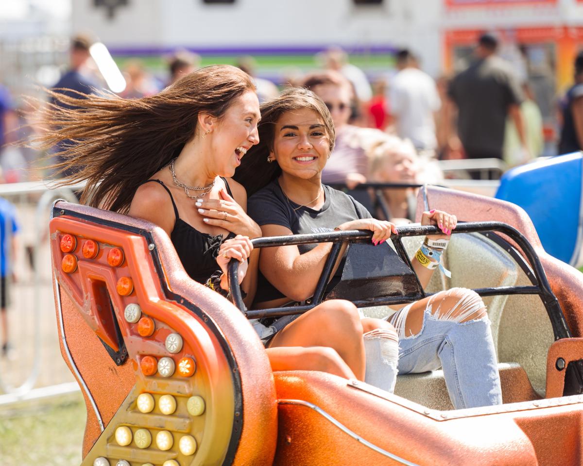 Two girls riding a carnival ride at the Northern WI State Fair