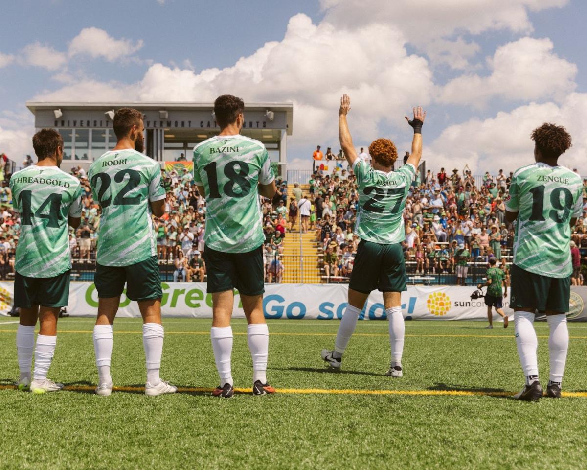 Vermont Green FC team on the Virtue field facing the bleachers.