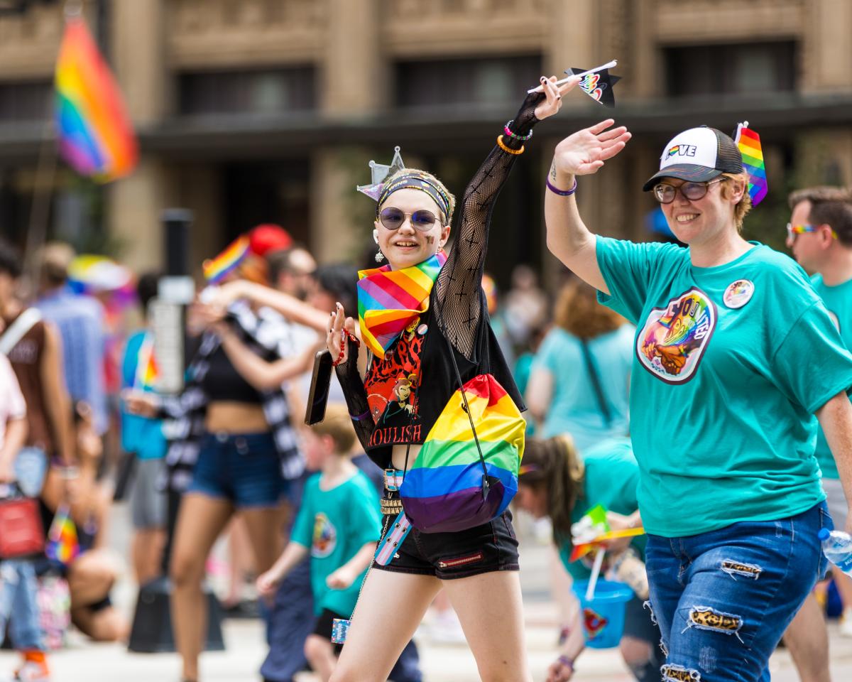 A woman dressed in colorful clothing walks in the Wichita Pride Parade