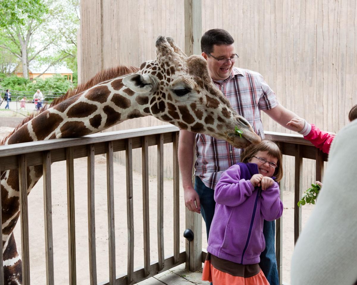 A family has fun feeding a giraffe at the Sedgwick County Zoo