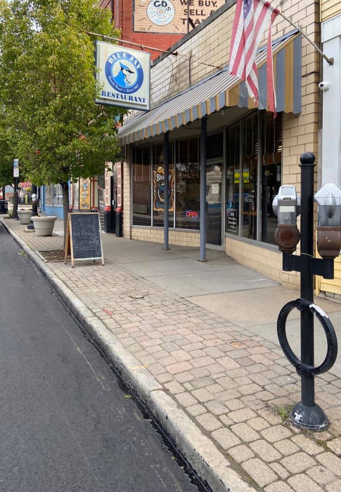 The image is of the outdoor facade of the Blue Jay Restuarant with their sign on display above the door.