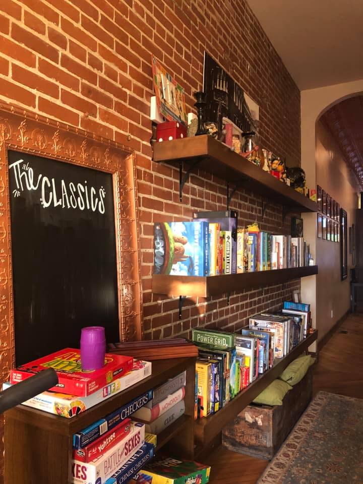 shelves of board games and chalk board titled "the classics"